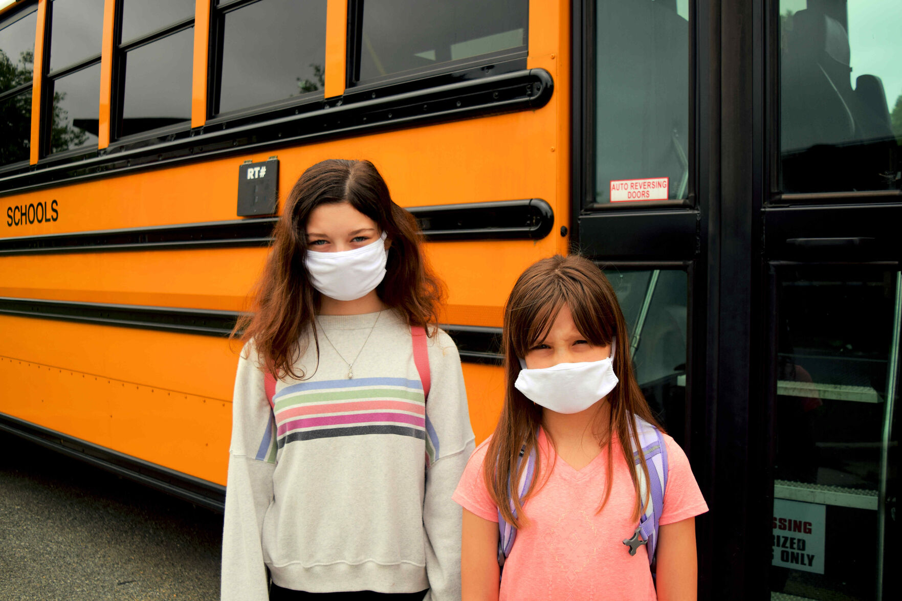 MASKED KIDS NEAR SCHOOL BUS